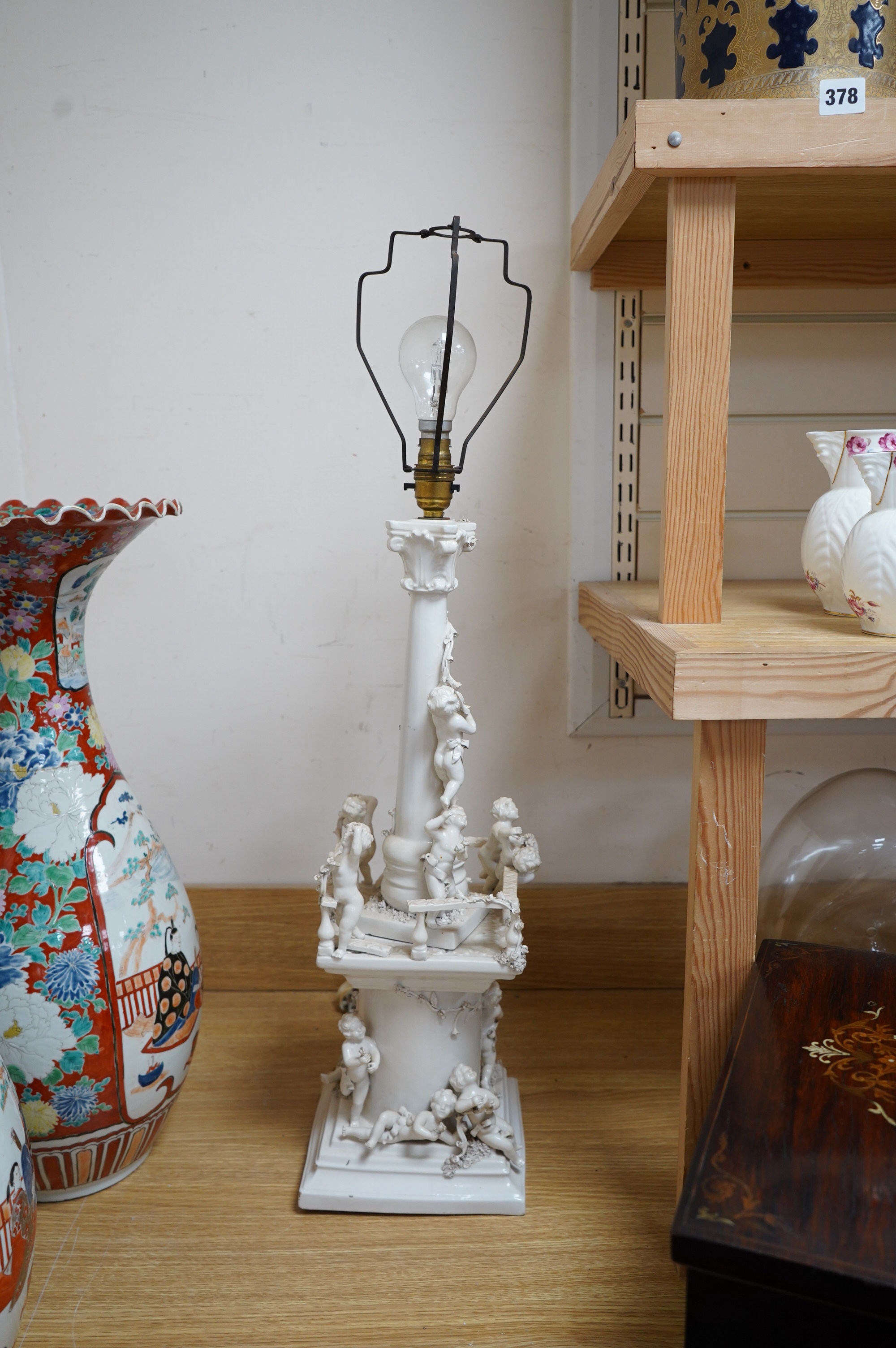 A modern Italian white maiolica ‘playing putti’ table lamp, 55cm. Condition - fair